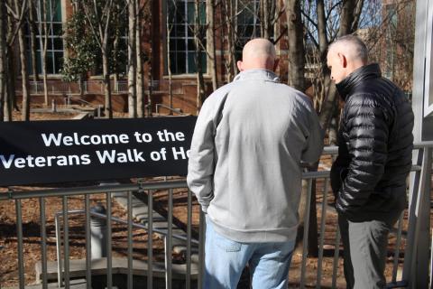 two men reading a sign Welcome to the Walk of Honor