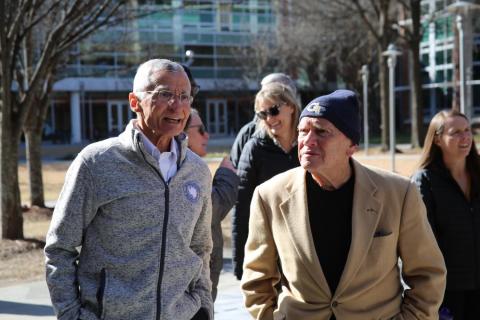 two men standing outside talking to eachother